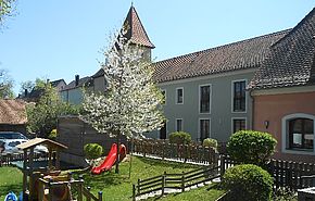 Willkommen - Das Bild zeigt unseren Garten mit einem blühenden Kirschbaum von der Schmetterlingsgruppe aus