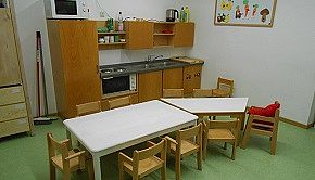 Kinderküche - Das Bild zeigt die Kinderküche mit Tischen und Stühlen im Vordergrund